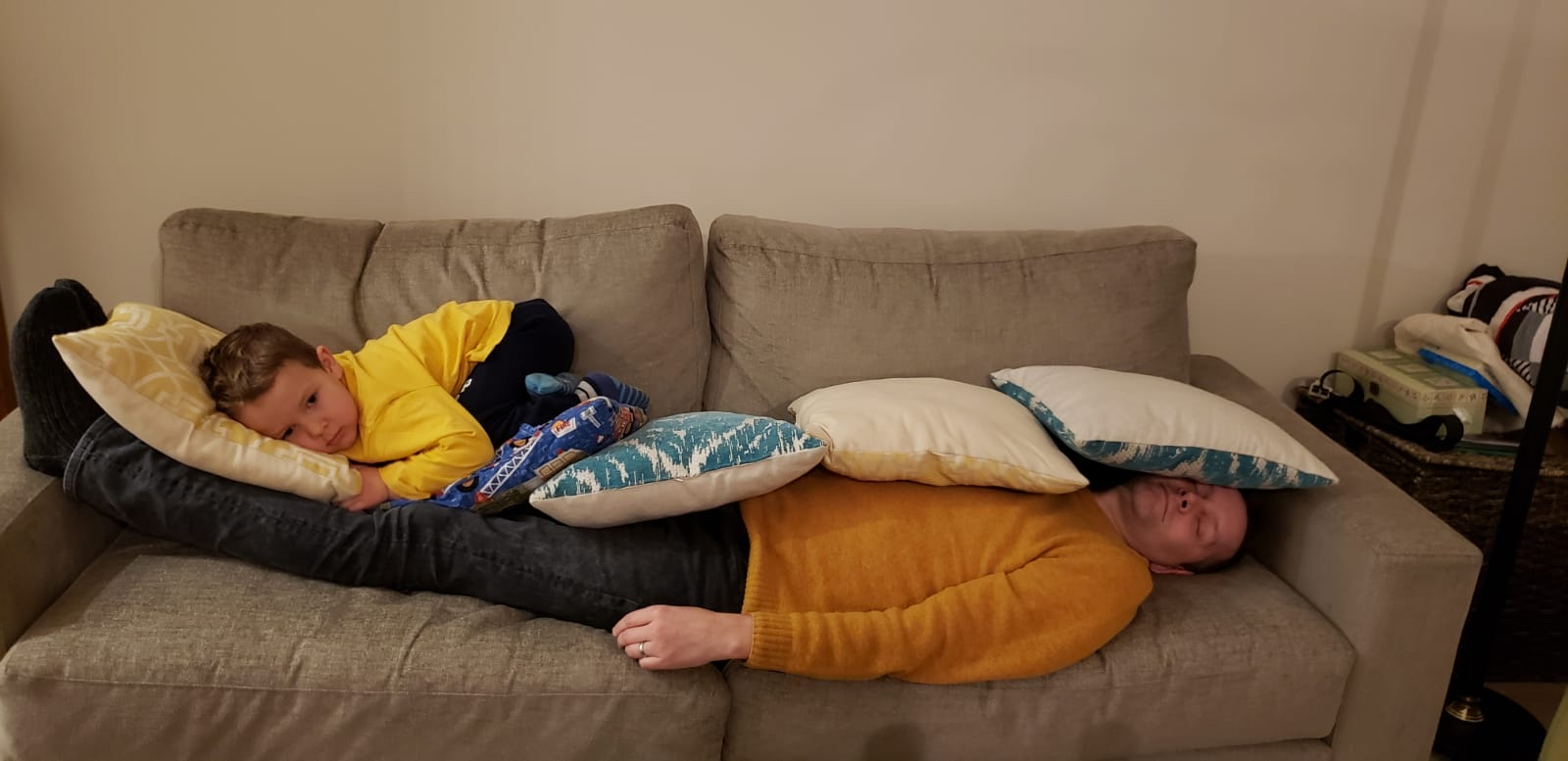 Tim covered by his child, becoming part of the furniture